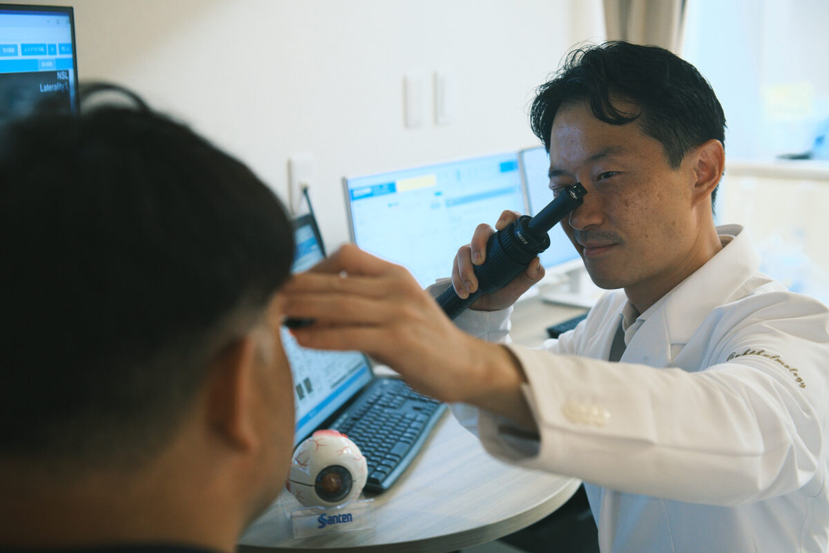 スコープで患者の目を診察する院長