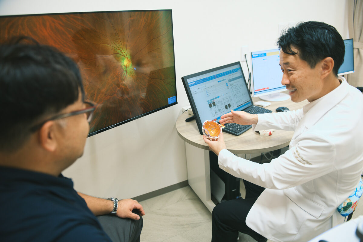 眼球模型を使って患者に説明する院長